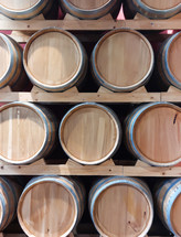 Display of oak barrels stacked on wooden shelves in a wine cellar