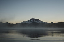 Early morning misty lake with a mountain in the background | Ripples of water | Peaceful | Dawn