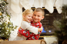 brother and sister hugging at Christmas 