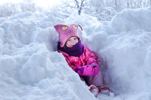 a toddler girl in a snow drift 