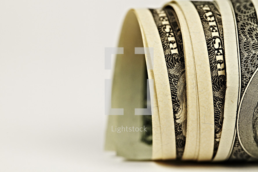 Dollar bills rolled together isolated on white