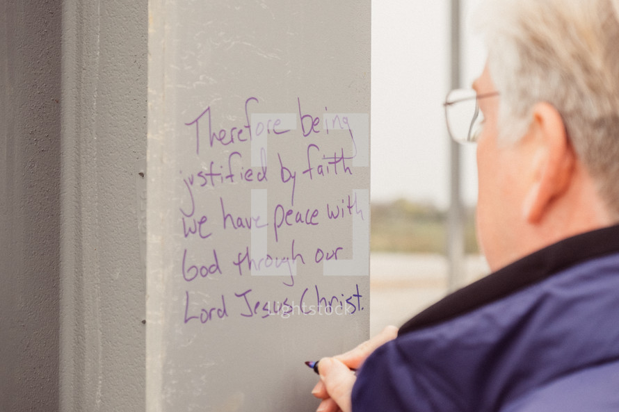 writing scripture on beams of a building under construction 