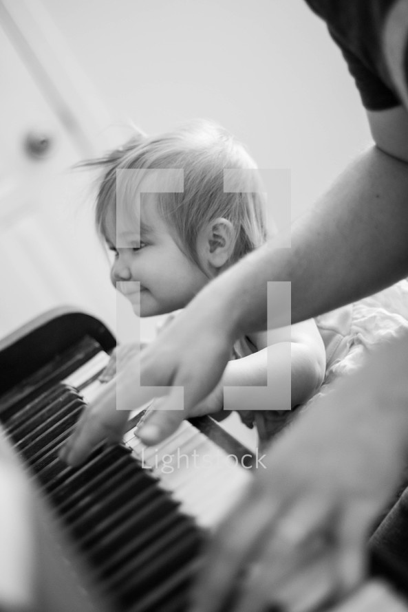 Baby girl learns to play piano with her dad.  Learning to worship.