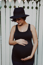 pregnant woman in a black hat 