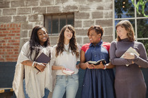 woman's group holding Bibles outdoors 