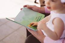 grandmother reading to an infant granddaughter 