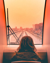 child looking out a train window 