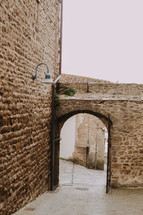 an archway leading to a narrow street 