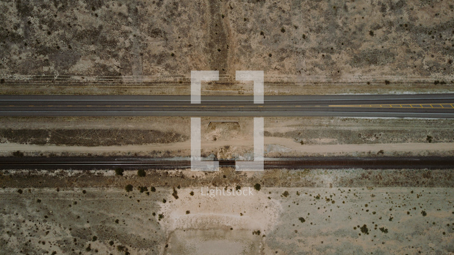 aerial view over road through desert landscape 