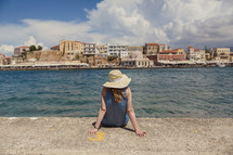 woman sitting on a sea wall 