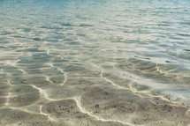 clear shallow ocean water and sandy ocean floor 