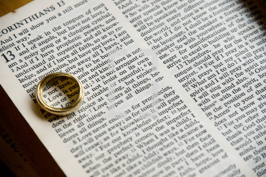 wedding band over the word Love in a Bible