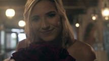a closeup of a bride holding a bouquet of roses looking at the camera 