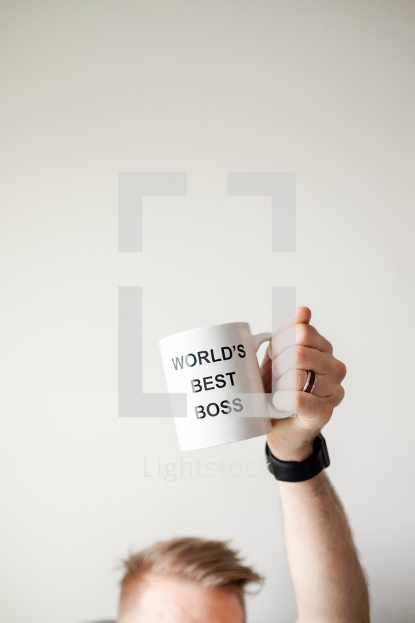 person holding up a World's Best Boss mug 