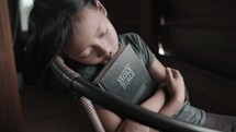Girl holding her Bible while resting