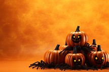 Halloween pumpkins with spider on orange background. Copy space.