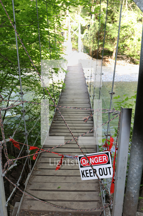 danger keep out sign on a swinging bridge 
