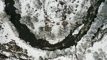 Drone footage of a river in the snow covered Colorado Rocky Mountains.