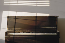 old piano in the light of a window