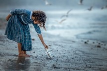 a girl finding a message in a bottle on a beach 