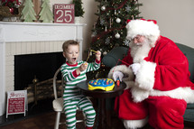 Santa and a little boy playing with toys 