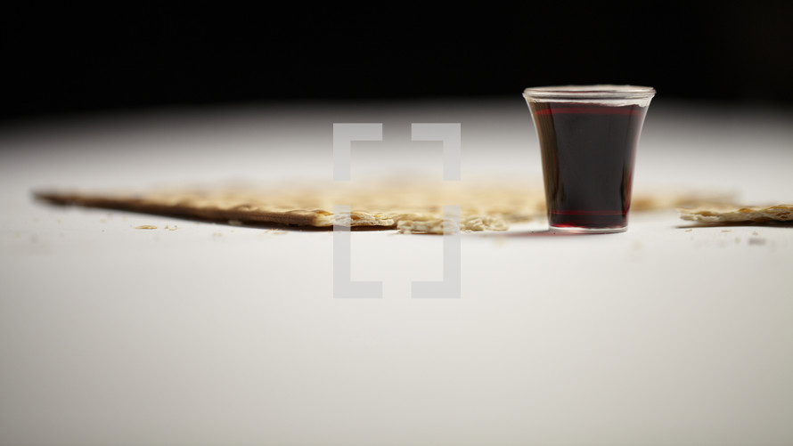 A communion cup and a broken piece of an unleavened cracker