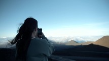 woman filming from the top of a mountain in Hawaii 