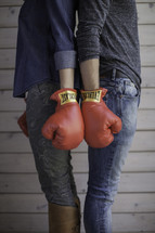 fighting couple wearing boxing gloves standing back to back 