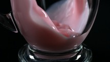 pouring a glass of pink milk 
