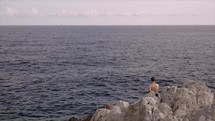 Man sitting alone observing the sea in France