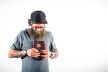 man with tattoos holding a Bible to his heart 