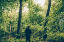 man standing alone in a forest 