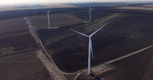 Aerial drone shot of Wind Turbines On Agricultural Land.