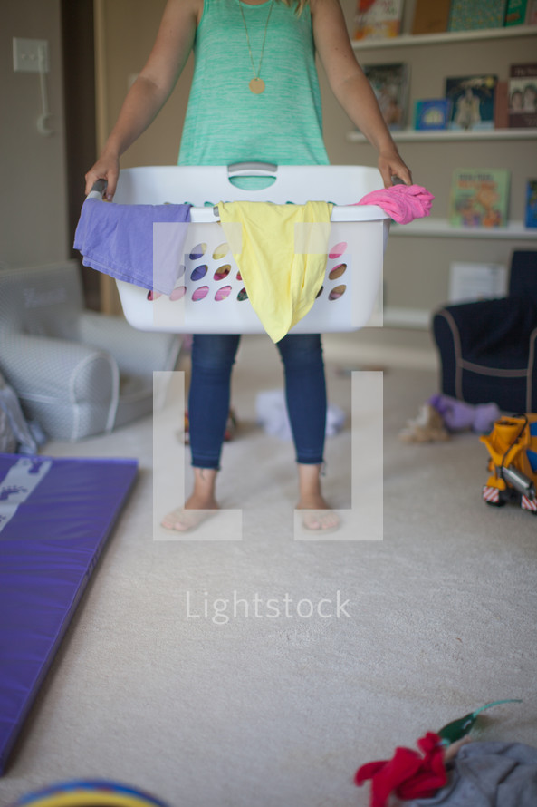 a woman holding a laundry basket 