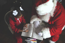 Santa and a little girl coloring together 