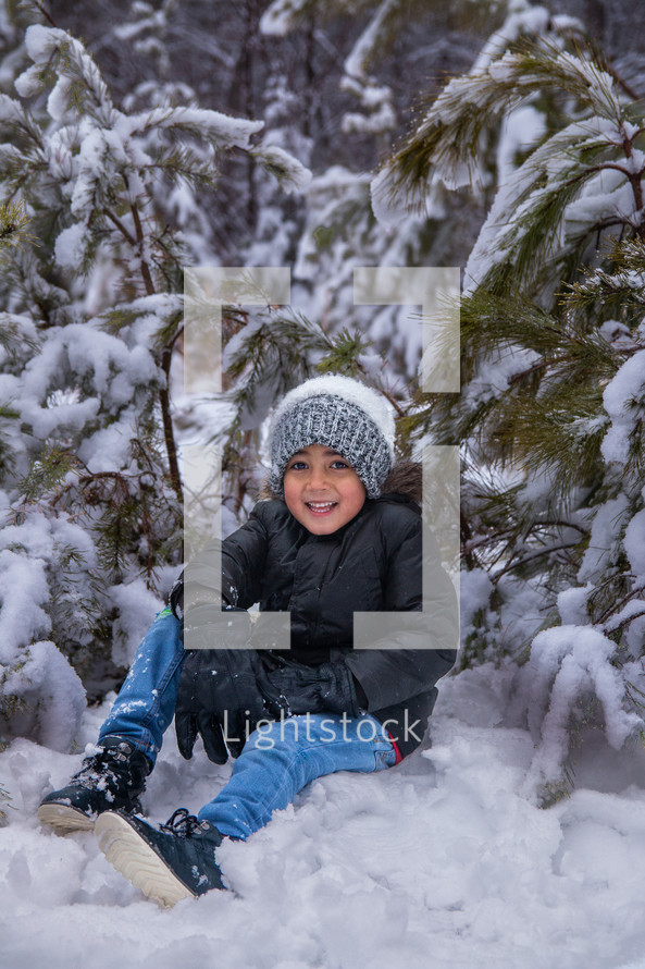 Boy sitting in a snowy background