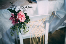 flowers on a white chair at a wedding reception 