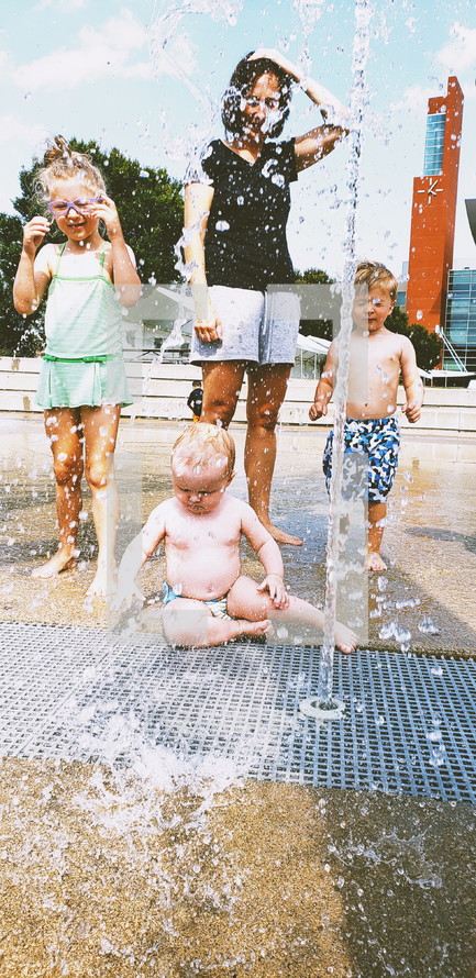 mother and kids at a splash park 