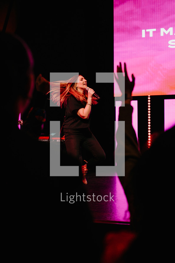 a woman singing on stage 