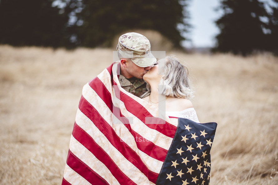 military couple wrapped in an American flag 