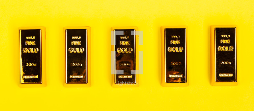 Bars of gold bullion on yellow background. Financial concept.