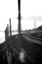 A railroad track curving along the coastline.