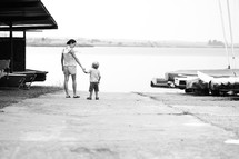 mother walking with toddler son on a boat ramp