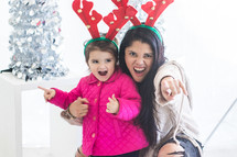 girls acting silly wearing reindeer antlers 
