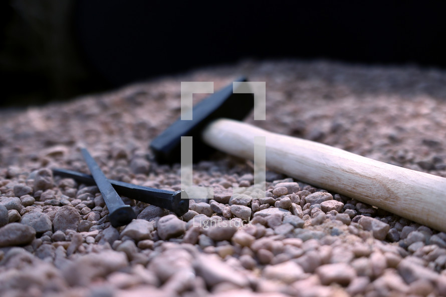 mallet and nails on stones 