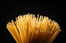 A pile of spaghetti dry on the table. Against a dark background. High quality photo