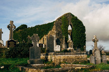 Old Cemetery in Ireland with Celtic Cross Gravestones and Old Church in Background