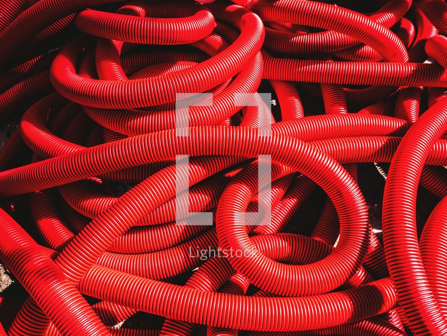  Industrial background. Plastic corrugated pipes, drainage in the roll, close-up. Red tubes or pipeline