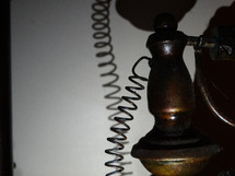 Abstract image of an old telephone casting shadow against white wall in dark lighting