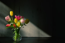 Vase of Tulips and shadows isolated on table